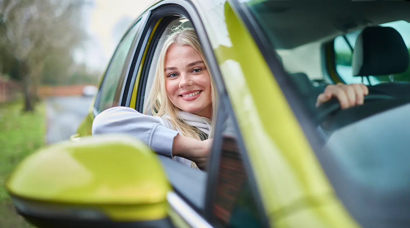 Young driver smiling inside vehicle